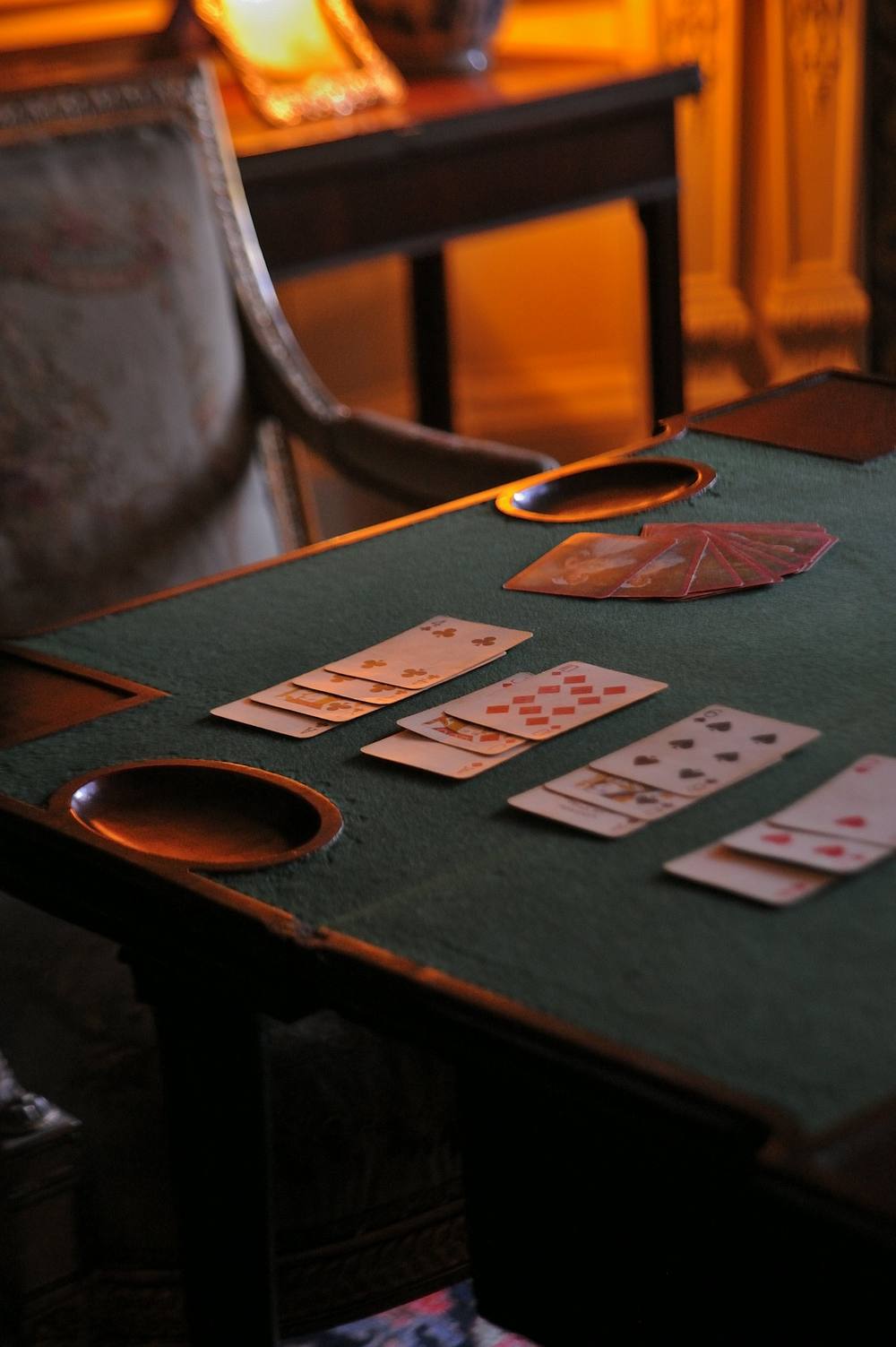 Old gaming table with green baize and cards